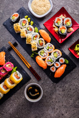 Obraz na płótnie Canvas Sushi Set sashimi and sushi rolls served on stone slate