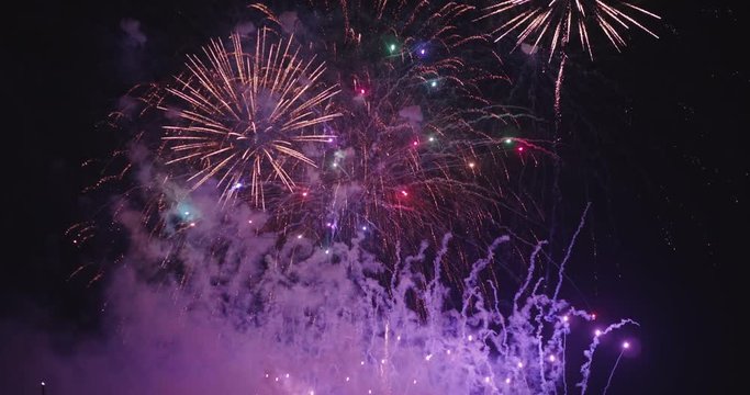Slow motion of majestic salute of celebratory colorful fireworks exploding in the sky.