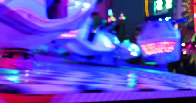 Blur night amusement atmosphere with illuminating blue light at "Octopus or Breakdance amusement ride" with speedy movement of rotating sloping platform and spinning seats in D&uuml;sseldorf, Germany.   