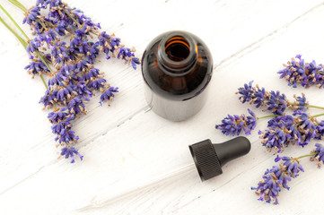 Obraz na płótnie Canvas Herbal remedies, holistic health care and alternative medicine concept theme with pipette or glass dropper in brown bottle of tincture surrounded by fresh lavender flowers on white wooden rustic table