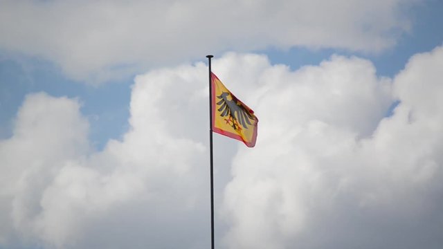 Official flag of the German federal waving in the wind. The flag of the German Federal President flying on a flagpole in a front of official residence Bellevue Palace in Berlin. 