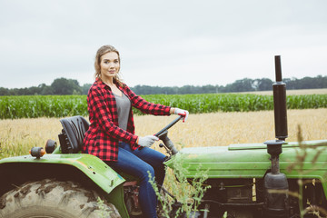 Outdoor shot of young woman sitting on tractor