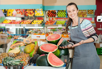 Positive Caucasian female store employee at fruit department