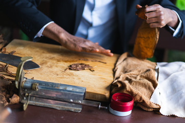 Process of making traditional cigars from tobacco leaves with hands using a mechanical device and press. 