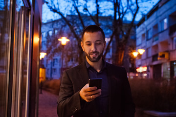 Young man using smart phone outdoor in the evening
