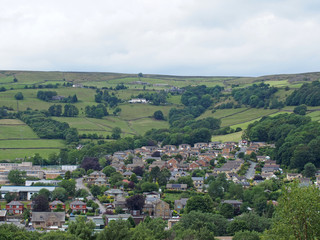 Fototapeta na wymiar a view of mytholmroyd from above in west yorkshire countryside surrounded by trees and fields and farms