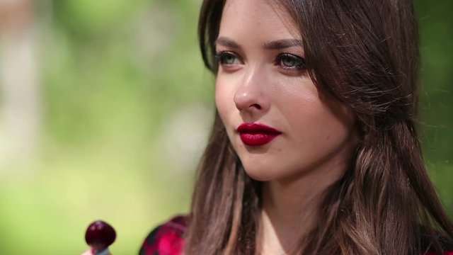 Pretty woman seductively eating cherry