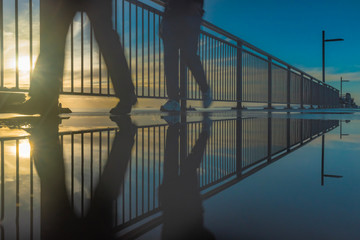 People walking on a pier during sunrise