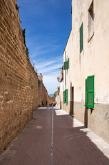 Fototapeta premium Narrow deserted street in the old medieval town of Alcudia, Mallorca