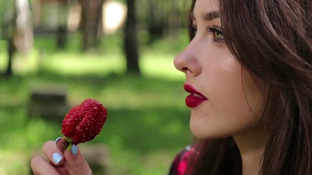 Pretty woman seductively eating strawberries