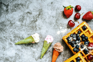 Background of tasty and sweet foods with red fruits and waffles, with negative space for summery design.