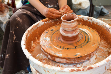 Close up pottery. Child trying to make a simple clay pot on a wheel
