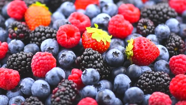 Berries. Various colorful berries background. Strawberry, raspberry, blackberry, blueberry closeup backdrop. Healthy eating. Rotation. Slow motion 4K UHD video footage. 3840X2160