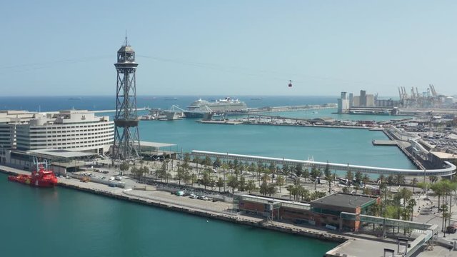 Drone view of Barcelona port Vell with cable car between ferry station and Montjuic, popular tourist attraction, moving over old harbour. Aerial tramway, cruise liners, beautiful seascape of Barcelona