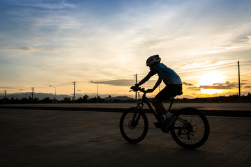 Fototapeta na wymiar man riding bicycle on the highway at dusk