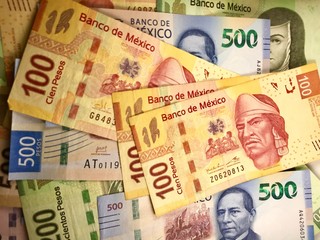 Fototapeta na wymiar Some mexican pesos bills spread over a wooden desk