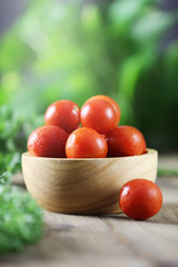 Fresh tomatoes in a bowl on table background.