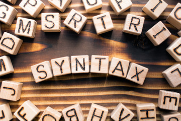 syntax  composed of wooden cubes with letters, grammatical arrangement of words in a sentence concept, the random letters around, top view on wooden background - obrazy, fototapety, plakaty