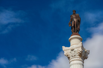 Pedro IV King of Portugal among clouds in Lisbon. Bronze statue at the top of monumental column erected in the cente of Rossio Square in 1874 (with copy space)