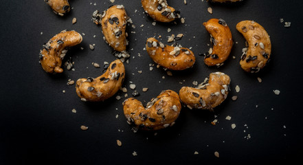 Naklejka premium Sesame Coated Cashew Nuts. Isolated on black background