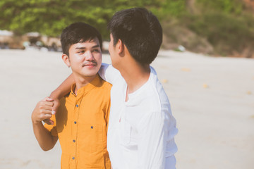 Homosexual portrait young asian couple standing hug together on beach in summer, asia gay going tourism for leisure and relax with romantic and happiness in vacation at sea, LGBT concept.