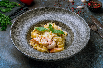 Fettuccine with shrimp and salmon on grey plate