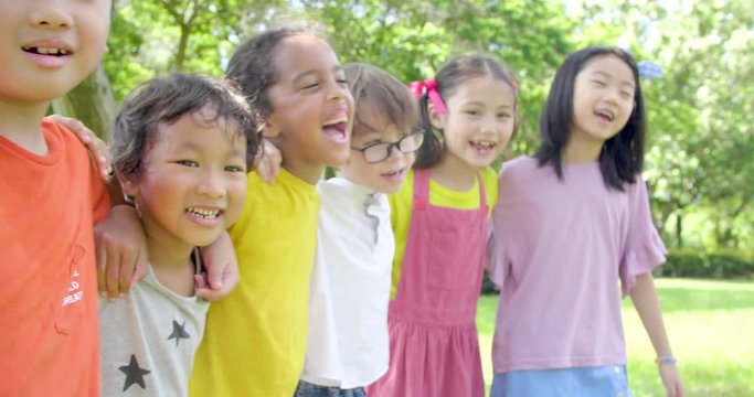 Multi-ethnic group of school children laughing and embracing