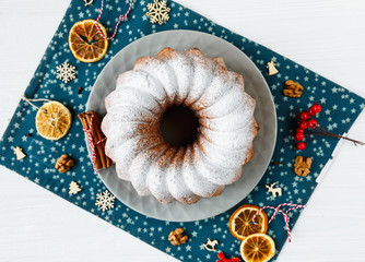 Traditional fruitcake for Christmas decorated with powdered sugar and fresh berry, top view. Delicioius Homemade Pastry. New year and Christmas celebration concept