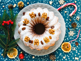 Traditional fruitcake for Christmas decorated with powdered sugar and fresh berry, top view. Delicioius Homemade Pastry. New year and Christmas celebration concept