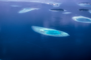 Fototapeta na wymiar Dieses einzigartige Bild zeigt die Malediven, die von einem Flugzeug von oben fotografiert werden. Sie können die Atolle im Meer gut sehen.