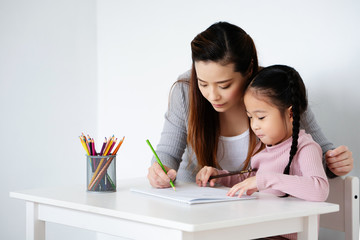 Learning Asian kid girls are practicing drawing skills in the classroom. To create imagination,...