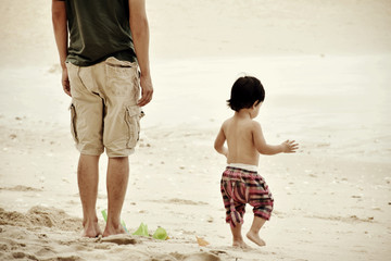 Father and son walking on the beach