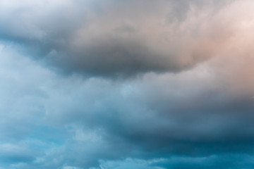 Obraz premium Stormy sky at twilight with clouds in various shades of blue, gray, and orange 