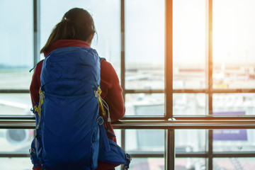 Obraz premium Traveler asia woman standing at the window in hall airplane departure with backpack , Selective focus, Travel concept.