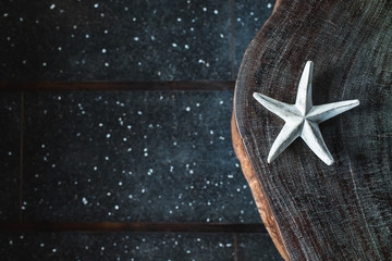 Dark background with one white handmade star, empty place and copy space. Eco concept. Wooden element in home decor and furniture.