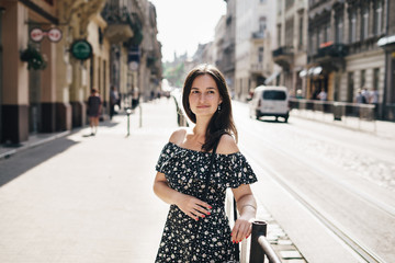 Fototapeta premium Young woman in a summer dress is walking around the streets of the city