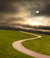 Paved road leading to an ominous sky.