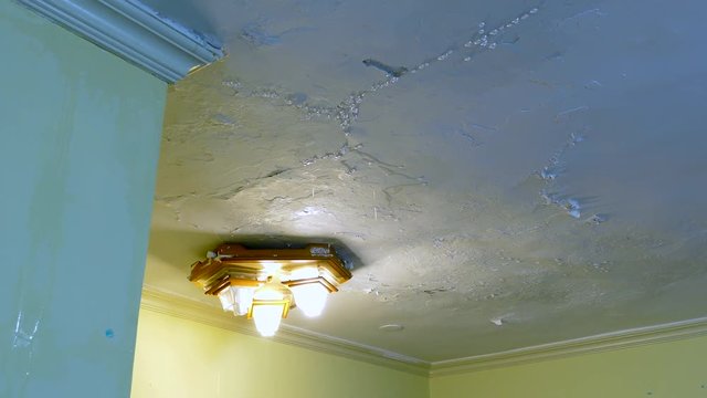 Peeling paint due to leak on an interior ceiling as result of water damage. A common house insurance claim.