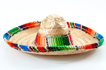 Cinco de mayo, traditional mexican hat and caribbean culture concept theme with close up on wicker or straw sombrero decorated in bright colors isolated on white background © Victor Moussa