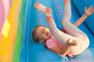 A cheerful child plays in an inflatable castle