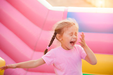 A cheerful child plays in an inflatable castle