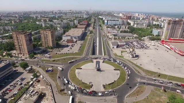 cars are moving on roads and round road junction in big city, aerial view