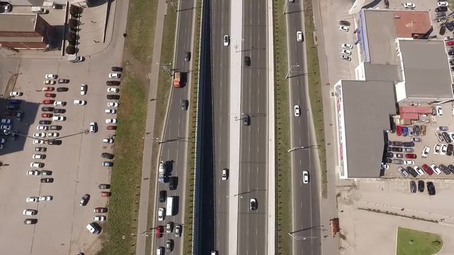 car traffic on road and parking area in city, moving aerial view