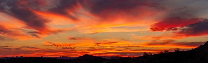 A sunset over a distant mountain in the Sonoran Desert of Arizona panorama