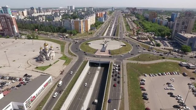 vehicles are moving on circle road and tunnel in modern city, aerial view