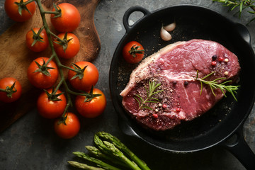 raw marinated meat in iron pan, with ingredients surrounding. top view,flat lay, horizontal image.