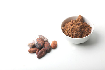 cacao beans and a bowl of cacao powder isolated on white background. Plan view