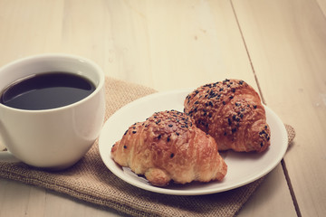 Croissant and coffee  isolated on wood table