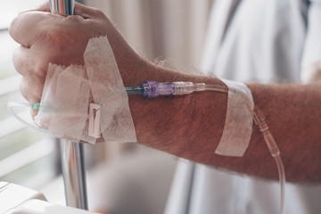 Dropper in a man's hand in a hospital. close-up