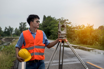 Young man engineer is using Surveyor equipment tacheometer or theodolite worker on the road.